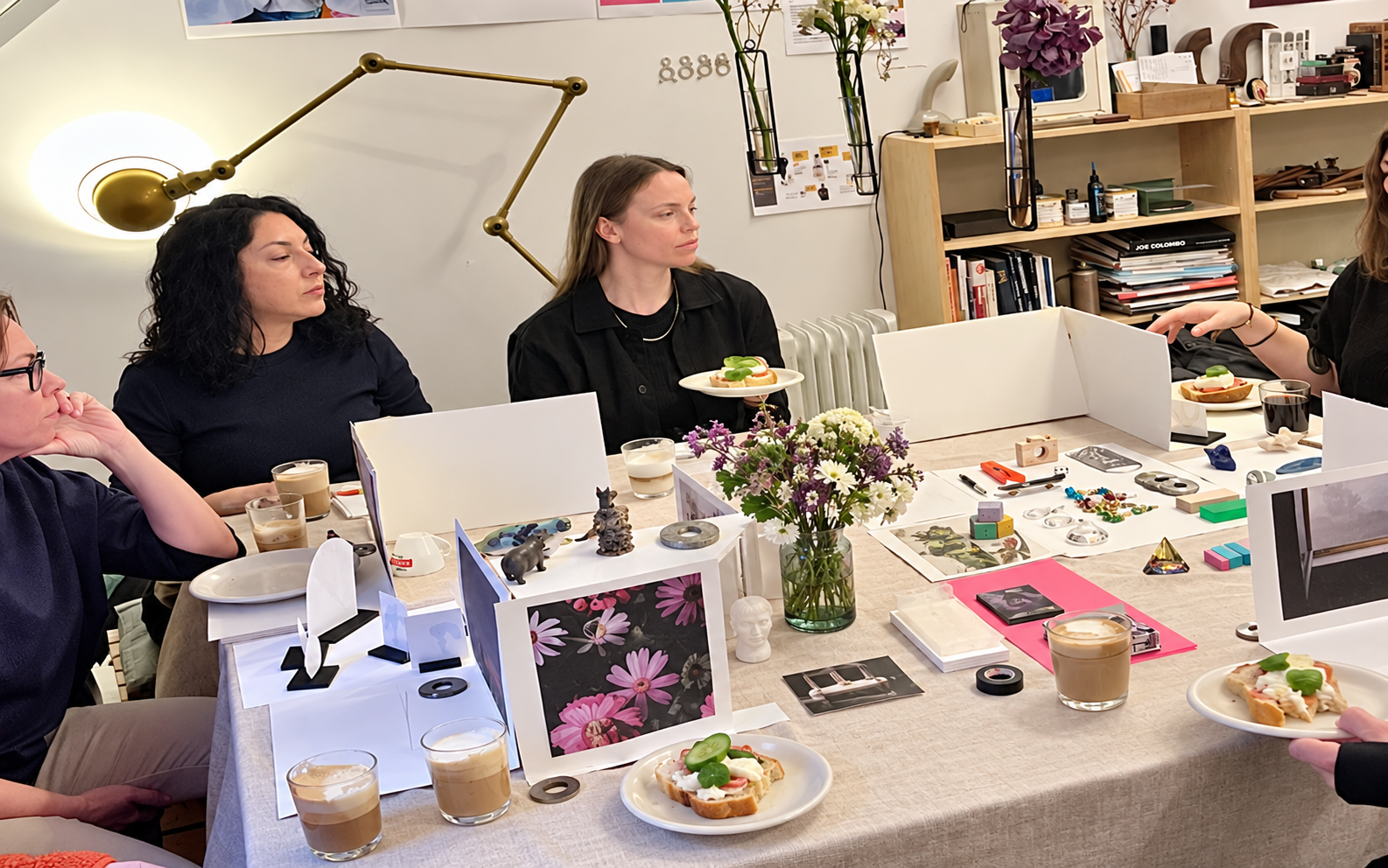 Deltagare kring ett arbetsbord under en workshop i en gammal smedja