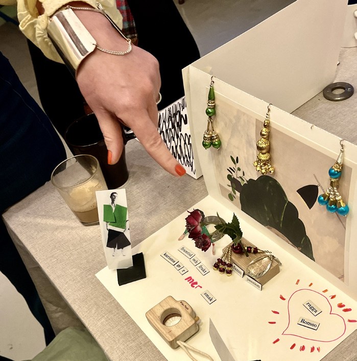 En hand pekar på ett scenario med små modeller, former och material